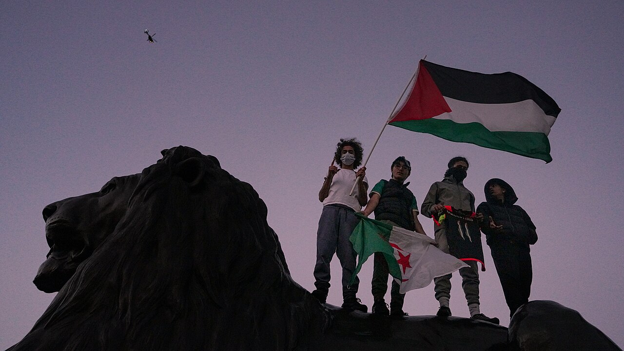 Čtyři protestující, jeden s palestinskou vlajkou a jeden s vlajkou Pákistánu, vyjadřují solidaritu s Palestinci, Alasdair Hickson