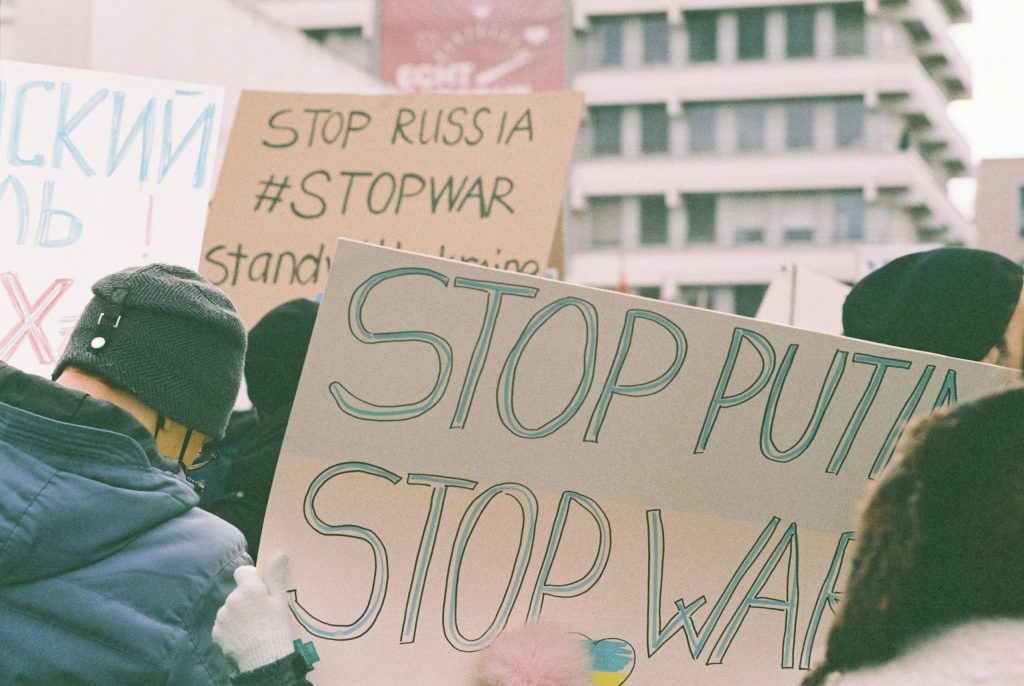 Protest signs at a rally expressing anti-war and anti-Putin sentiments.