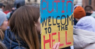 A Person Holding a Placard that Says Putin Welcome to the Hell