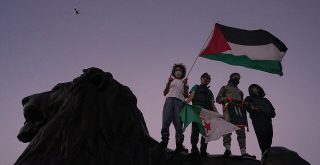 Čtyři protestující, jeden s palestinskou vlajkou a jeden s vlajkou Pákistánu, vyjadřují solidaritu s Palestinci, Alasdair Hickson